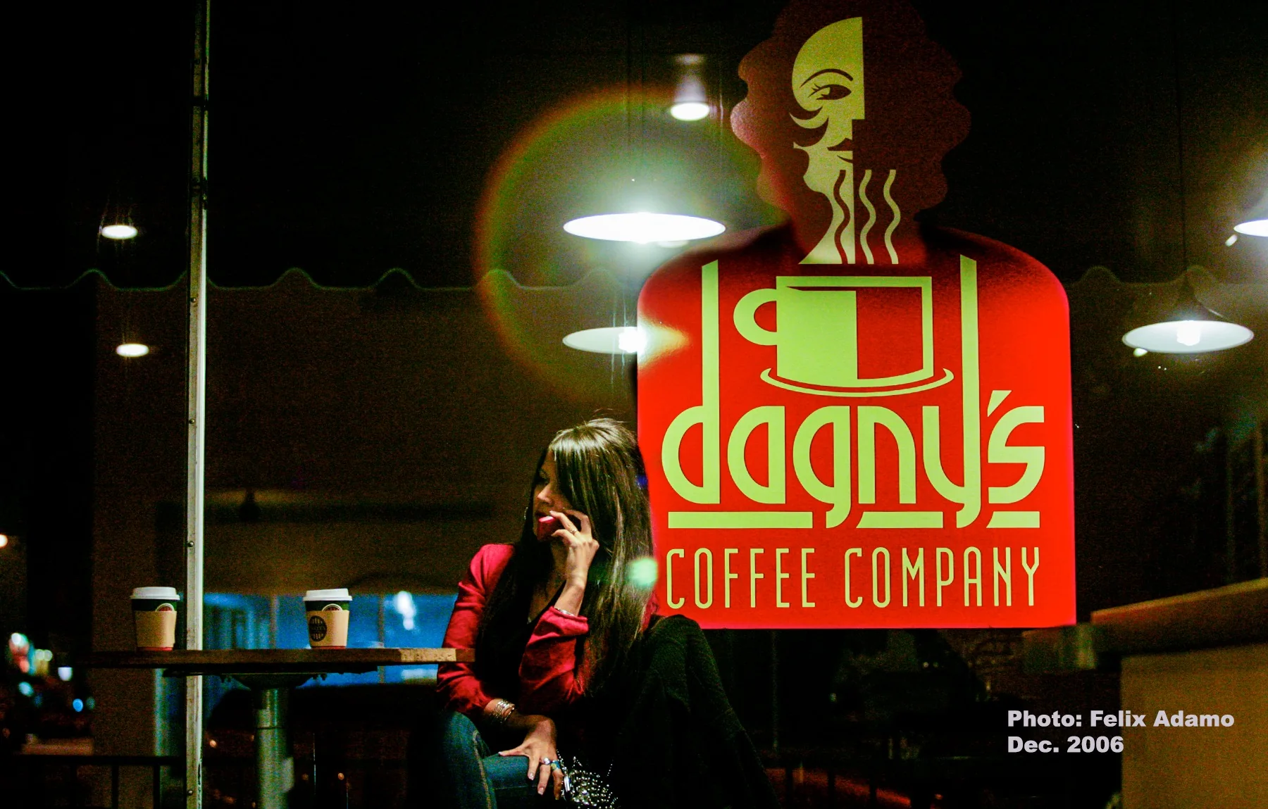 A customer seated beside the glowing Dagny's sign at night in 2006