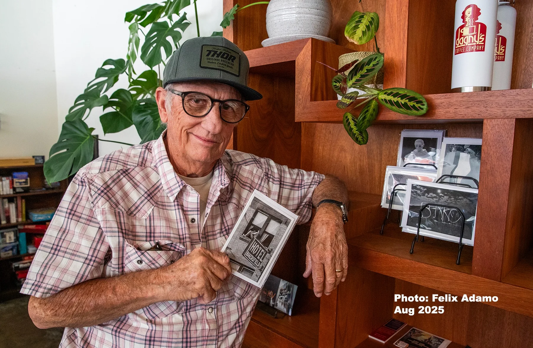 A man holding an archival Dagny's photograph inside the coffee shop in 2025